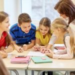 group of school kids writing test in classroom